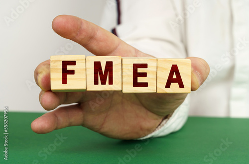 In the man's hand are cubes with the inscription - FMEA photo