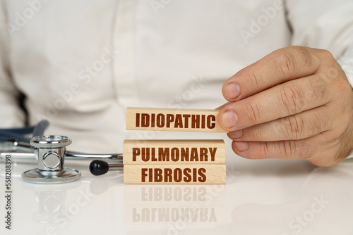 On a white surface, a stethoscope and wooden plates with the inscription - Idiopathic pulmonary fibrosis photo