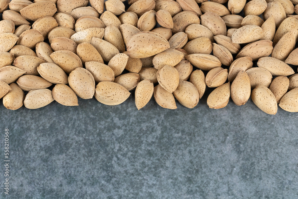 Heap of raw peeled almonds on a gray background, top view. copy space. Pattern of almond seeds. Nutty background. Heap of raw peeled almonds on a gray background, top view. copy space. Pattern of almond seeds. Nutty background.