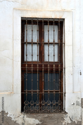 The beautiful exterior facade with a wooden door in the historic of Cordoba Spain © Fernando Batista