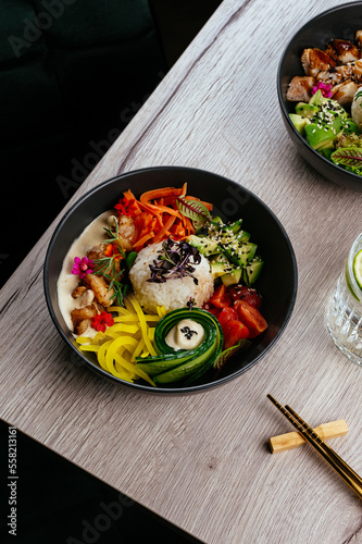 asian poke bowl with rice, vegetables and chicken