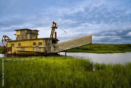old abandoned factory gold mining equipment in Alaska on a stormy sunny day 