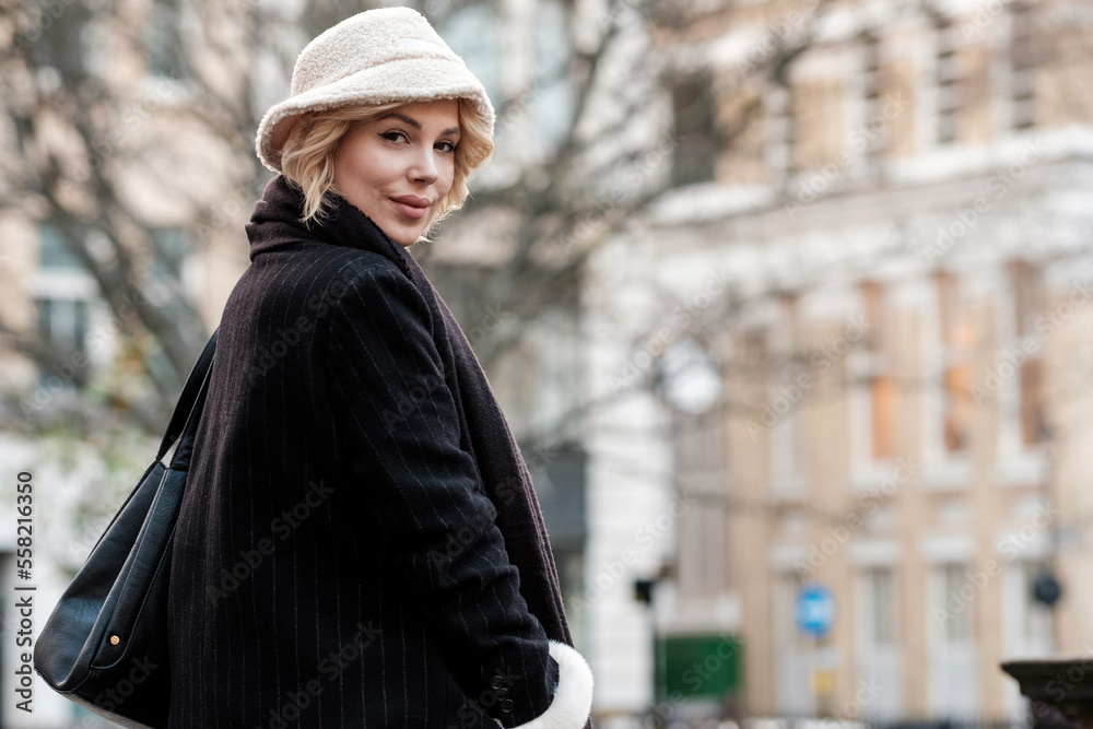 Portrait of young blonde woman looking at camera with building behind. Portrait of young blonde woman looking at camera with building behind.