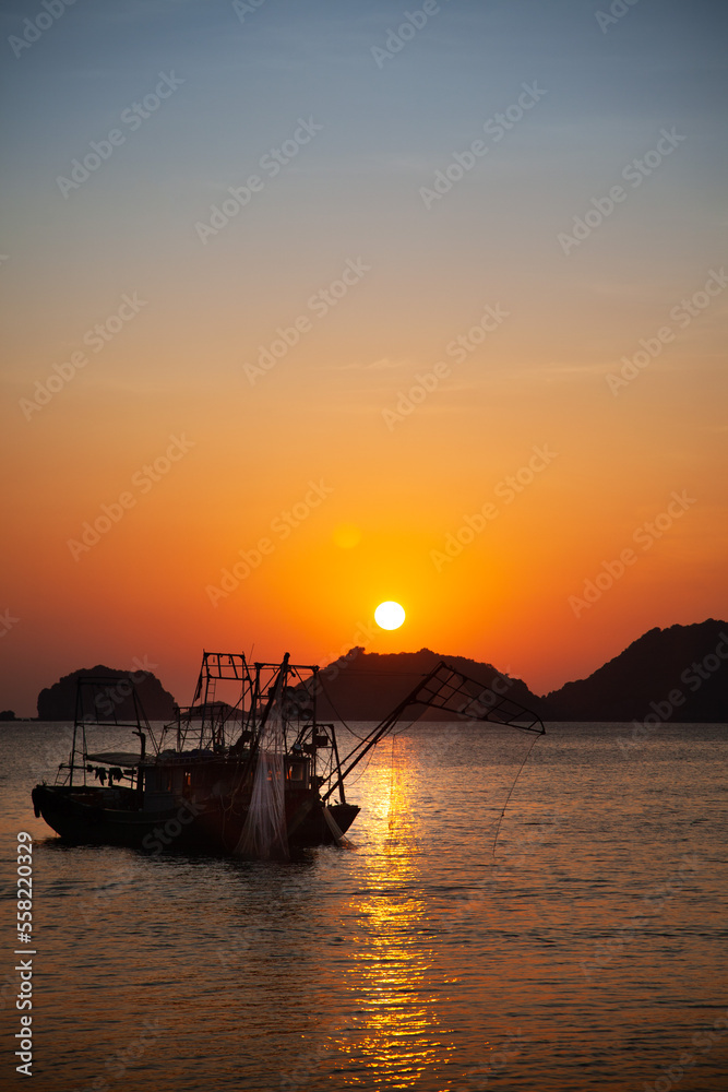 Bateau de pêche dans la mer au Vietnam au coucher du soleil