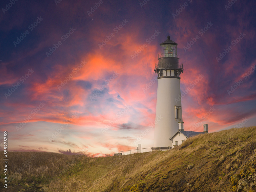 White tall lighthouse at dusk. There are pink storm clouds in the dark sky. High hilly shore of the ocean. Picturesque landscape. There is no one in the photo. Romance, history, tourism.