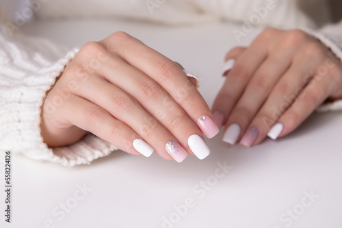 Beautiful female hands with pink and silver manicure nails on white background