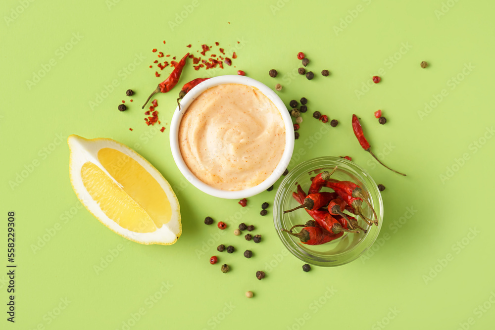Bowl of tasty chipotle sauce and spices on green background Bowl of tasty chipotle sauce and spices on green background