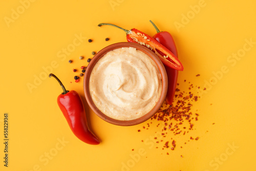 Φωτογραφία Bowl of tasty chipotle sauce and fresh jalapeno peppers on color background