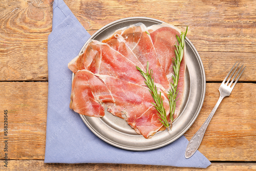 Plate with slices of tasty ham and rosemary on wooden background Plate with slices of tasty ham and rosemary on wooden background