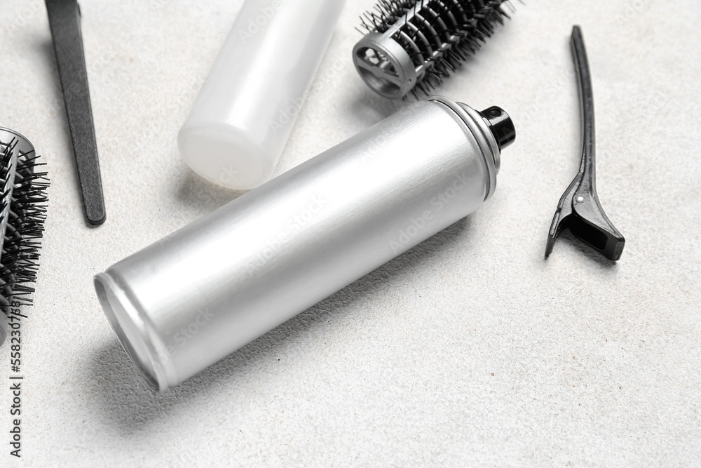 Hair sprays with clips and brushes on light background, closeup Hair sprays with clips and brushes on light background, closeup