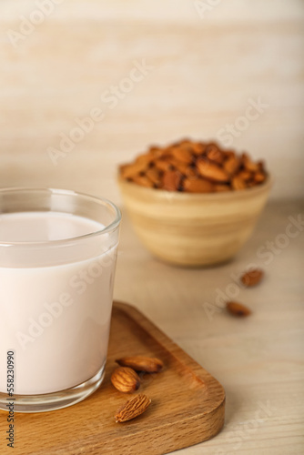 Glass of healthy almond milk on wooden table, closeup photo