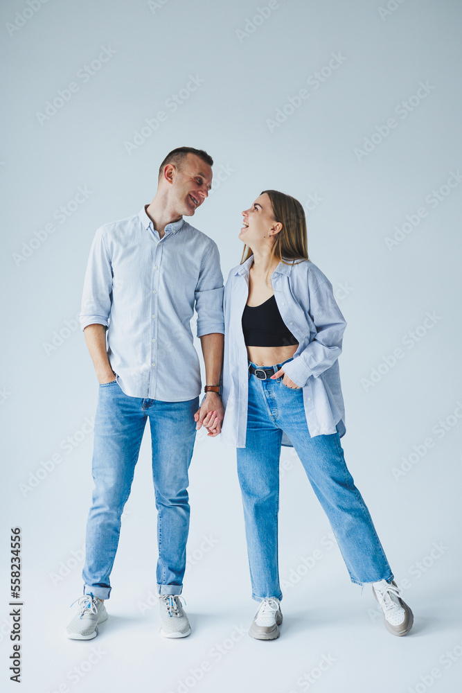 Relationship concept - photo of a happy couple in white shirts and jeans on a white background. Happy young couple Relationship concept - photo of a happy couple in white shirts and jeans on a white background. Happy young couple