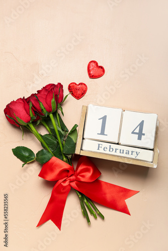 Cube calendar with date 14 FEBRUARY, red roses and hearts on beige background