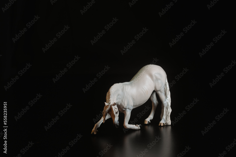Black toy horse isolated on black background Black toy horse isolated on black background