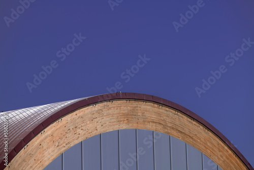 Semicircular modern design roof built with three materials, wood, glass and metal and blue sky © Toyakisfoto.photos