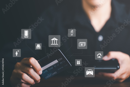 Young businessman using credit card to make financial transactions via smartphone, payment concept with wireless communication technology, focus on consumer safety and cashlessness.