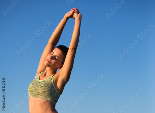 Young woman exercise and stretch in the nature on a sunny summer day