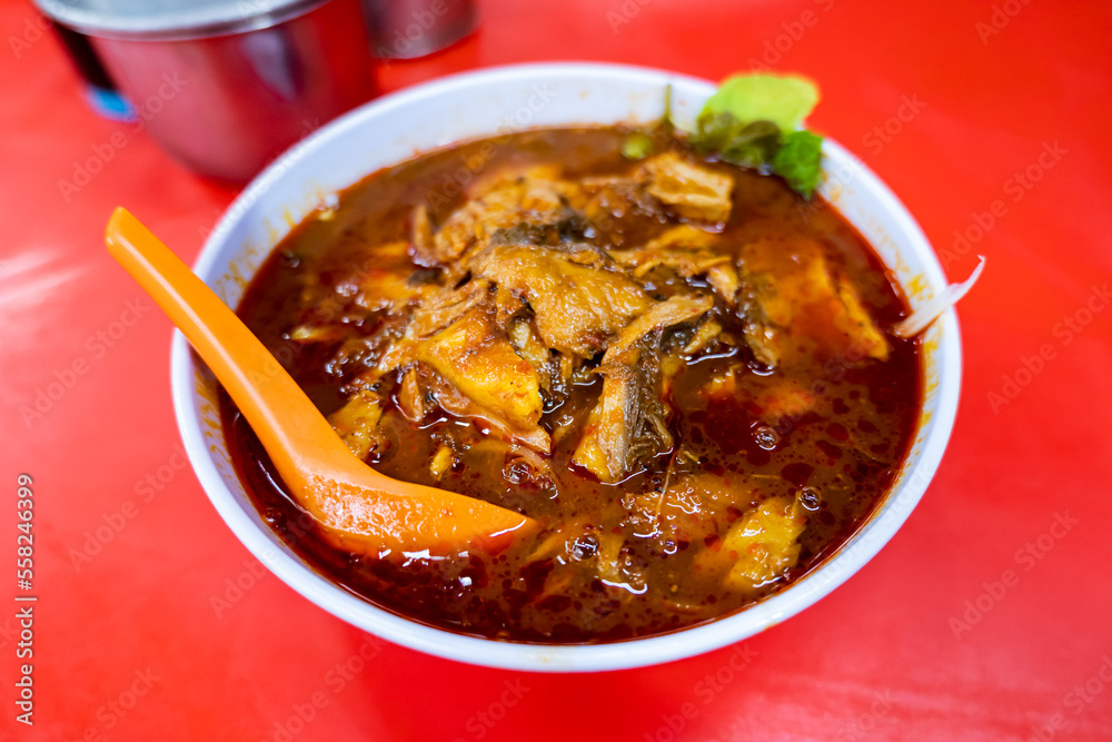 Laksa, famous noodle dish in Malaysia and Singapore, served in street food stall. Laksa, famous noodle dish in Malaysia and Singapore, served in street food stall.