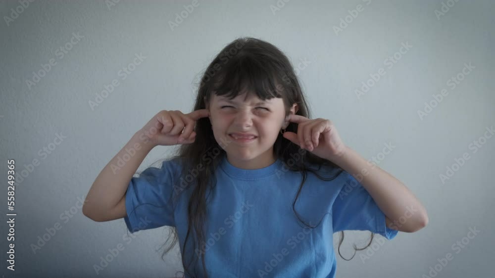 Child suffer from noise indoor. A frustrated little girl suffer from noise from neighbors in the room. Child suffer from noise indoor. A frustrated little girl suffer from noise from neighbors in the room.
