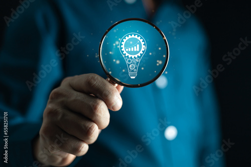 Search idea invest indicators long-term.Business man hand holding magnifier glass with virtual Idea concept.Business investment earning income concept.