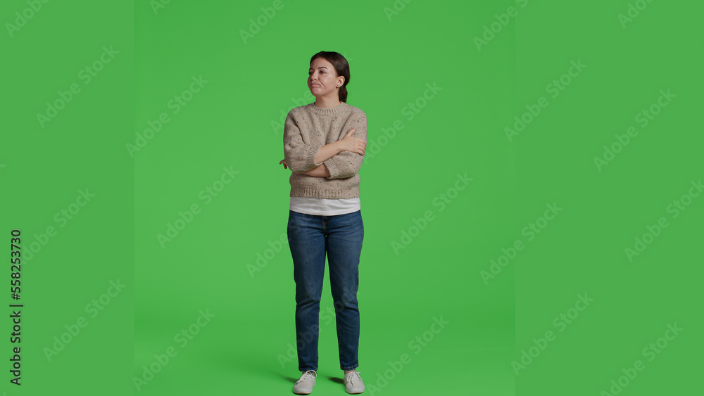 Front view of woman sitting curious and impatient in studio, posing on greenscreen backdrop. Young adult standing over isolated green screen background, being thoughtful and waiting, full body. Front view of woman sitting curious and impatient in studio, posing on greenscreen backdrop. Young adult standing over isolated green screen background, being thoughtful and waiting, full body.