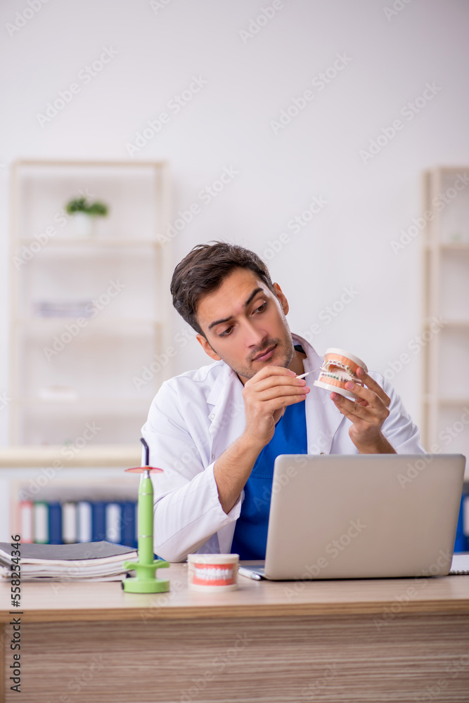 Young male dentist working in the clinic