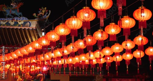 Chinese paper lanterns light up hung throughout the courtyard in a temple during Chinese New Year in Thailand.