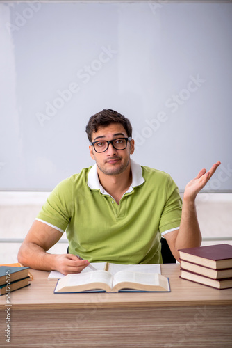 Young male student preparing for exams in the classroom