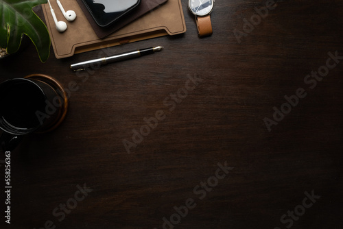 Modern workspace with smart phone, notebook, coffee cup and wristwatch on wooden table. Copy space for your text.