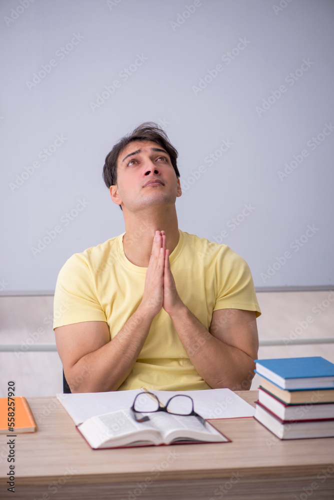 Young male student sitting in the classroom Young male student sitting in the classroom