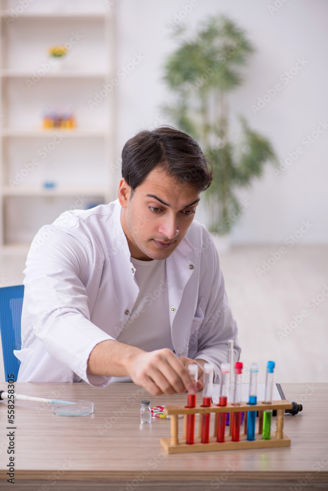 Young male chemist working at the lab Young male chemist working at the lab
