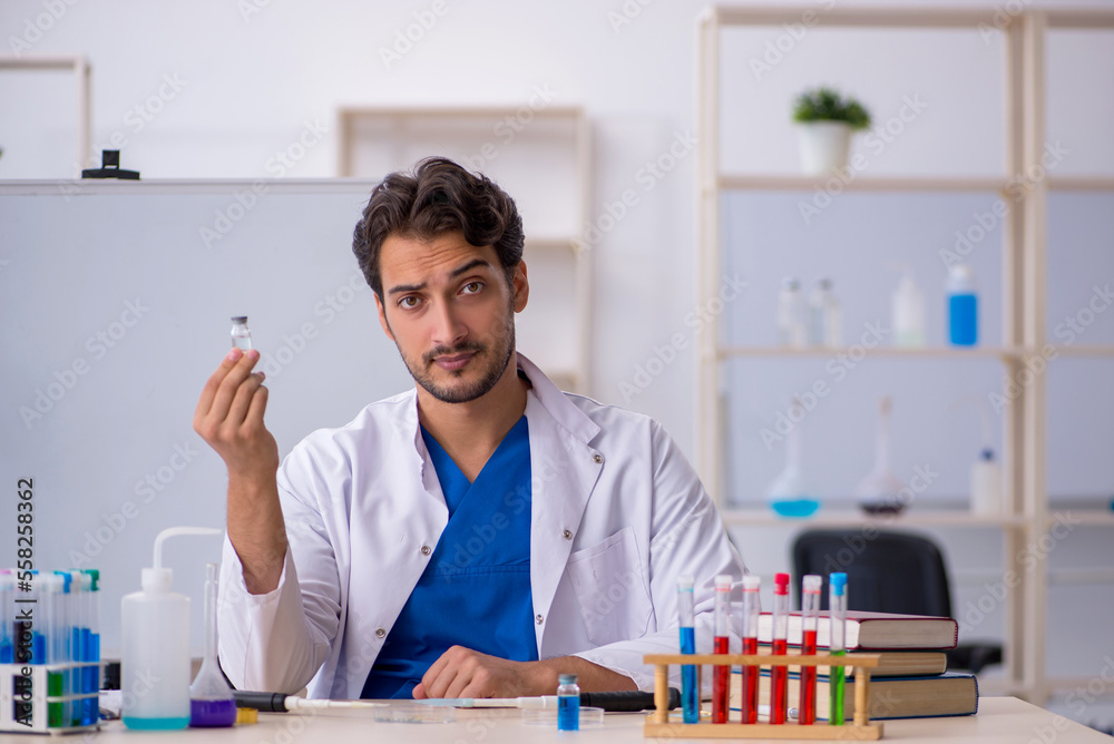 Young male chemist working at the lab