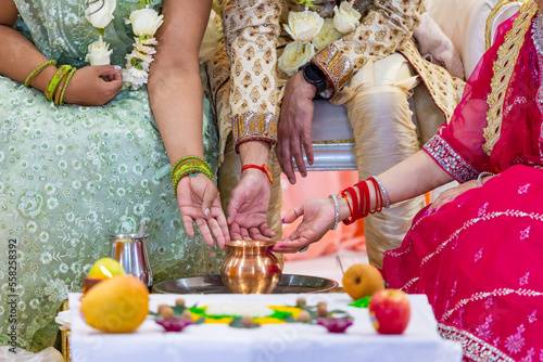 Indian Hindu wedding ceremony pooja ritual items and hands close up