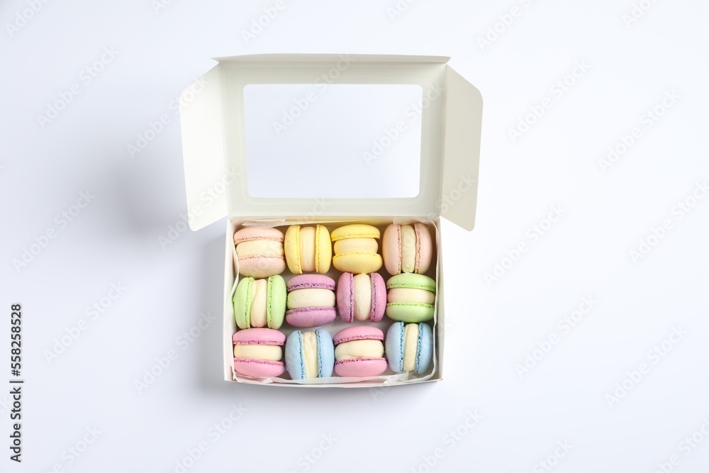 Many delicious colorful macarons in box on white background, top view Many delicious colorful macarons in box on white background, top view
