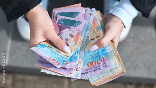 A girl counts old Venezuelan money. photo