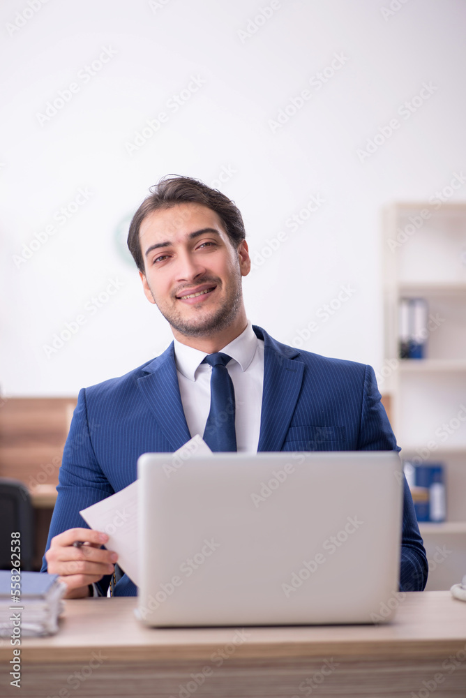 Young male employee and too much work in the office Young male employee and too much work in the office