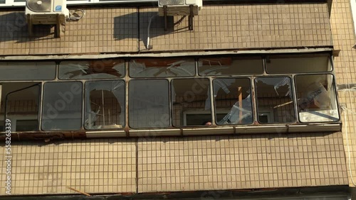 Consequences of rocket attack on the center of Ukraine. Funnel from a drone explosion. Attack of Iranian Shahed 136 drones on Kyiv. Damaged residential building. Broken windows and holes from debris. 