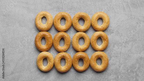 Many tasty dry bagels (sushki) on grey table, flat lay photo