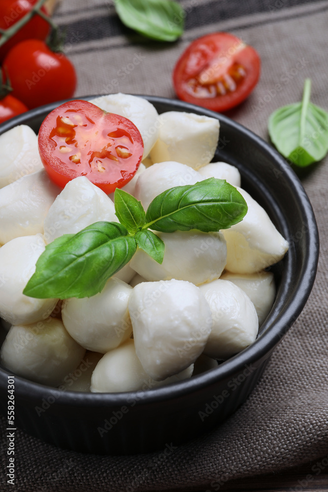 Delicious mozzarella balls, tomatoes and basil leaves on table, closeup Delicious mozzarella balls, tomatoes and basil leaves on table, closeup