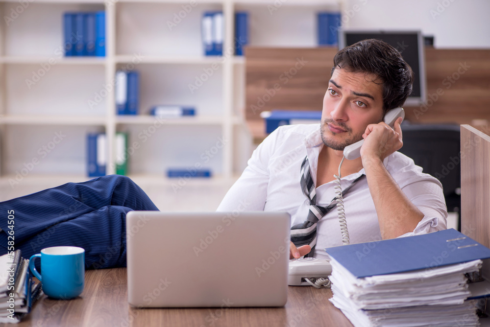 Obraz premium Young male employee unhappy with excessive work at workplace