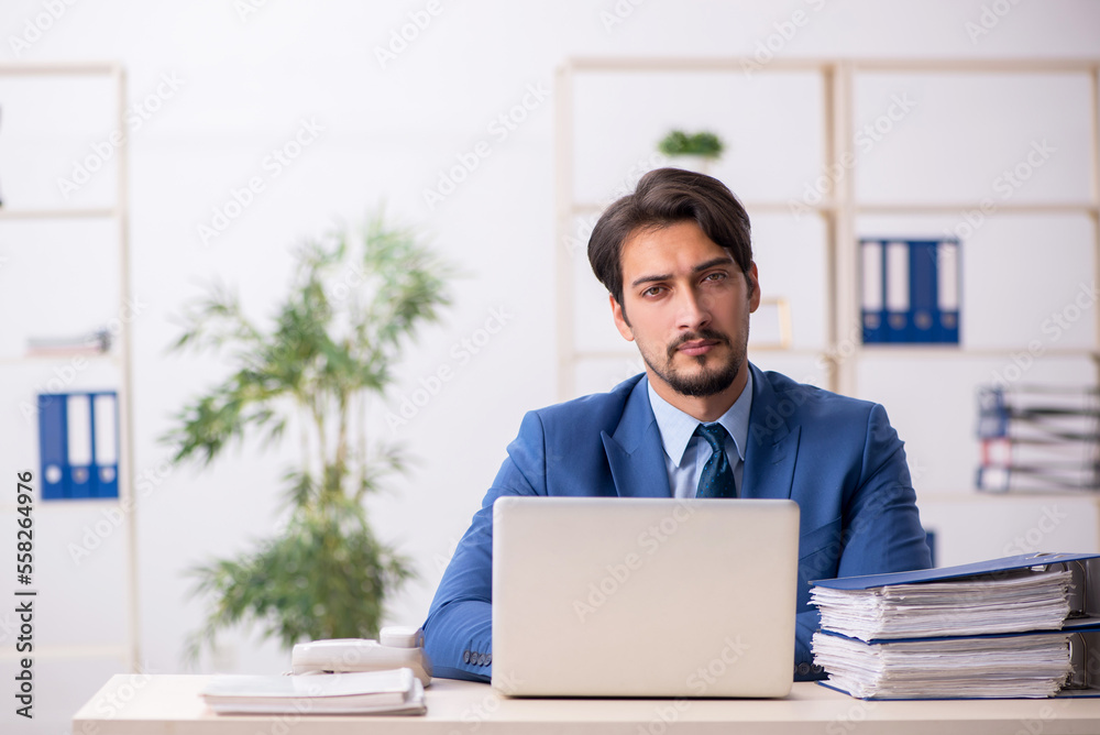 Fototapeta premium Young male employee and too much work in the office