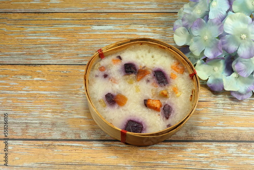 Traditional sticky rice dressing with purple sweet potato and taro serving on the bamboo basket. Mock up product of ancient sweet dessert menu.