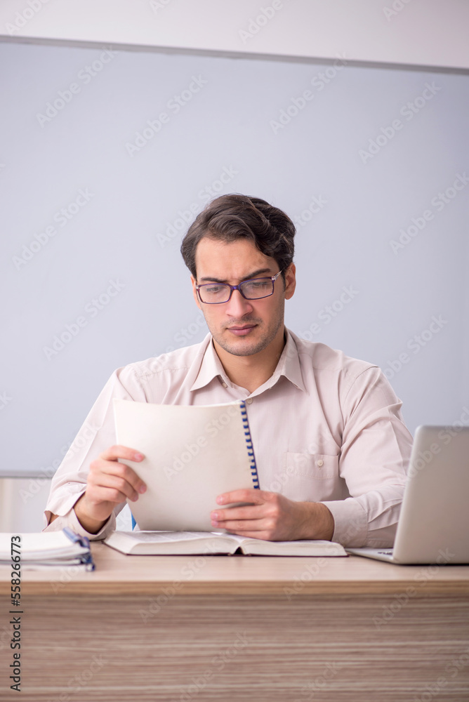 Young male teacher student sitting in the classroom Young male teacher student sitting in the classroom