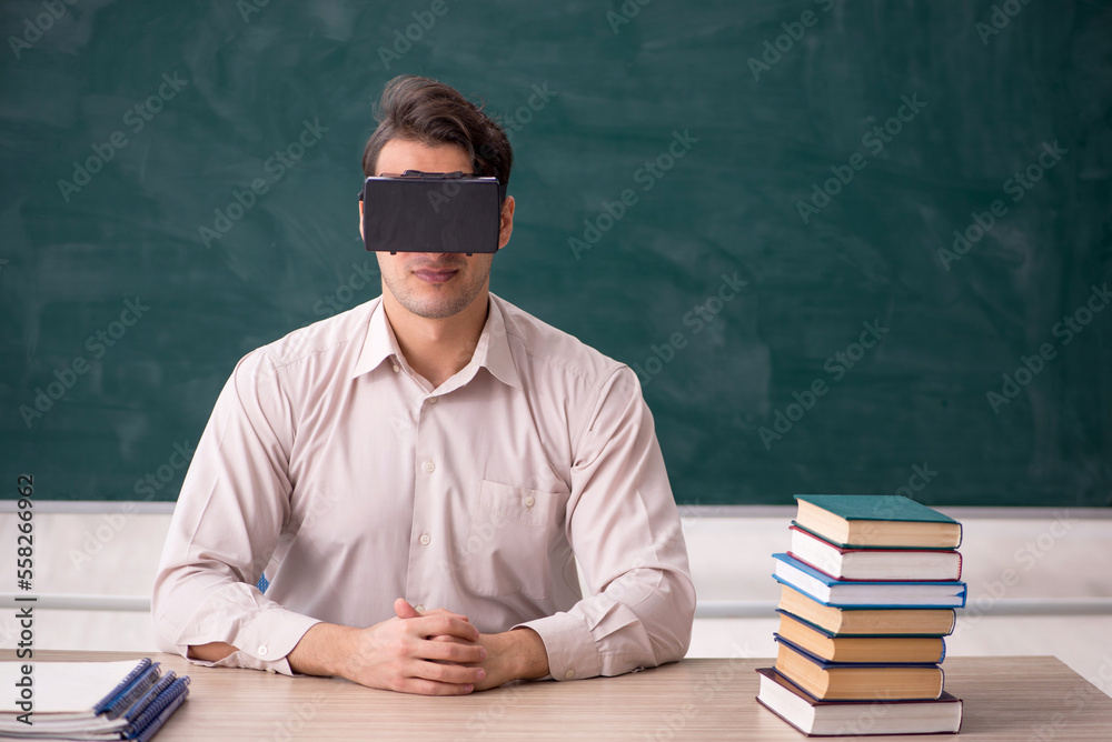 Young male student wearing virtual glasses in the classroom