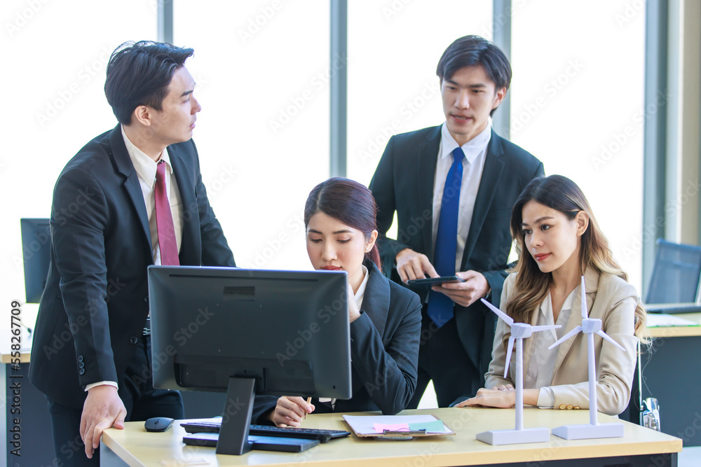 Millennial Asian young professional successful businesswoman in formal suit with female and male businessman colleague in formal suit brainstorming in company office room. Millennial Asian young professional successful businesswoman in formal suit with female and male businessman colleague in formal suit brainstorming in company office room.