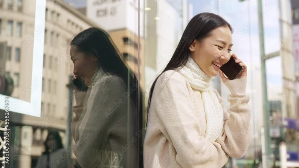 Asian woman talking on mobile phone during shopping at Shibuya district, Tokyo city, Japan with crowd of people walking background. Attractive girl enjoy travel city street on autumn holiday vacation Asian woman talking on mobile phone during shopping at Shibuya district, Tokyo city, Japan with crowd of people walking background. Attractive girl enjoy travel city street on autumn holiday vacation