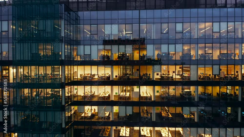 Aerial view of office windows of skyscrapers at night, International Business Center, Gdansk. Young creative people, businessmen, work at computers until late at night. Close-up of fifis windows