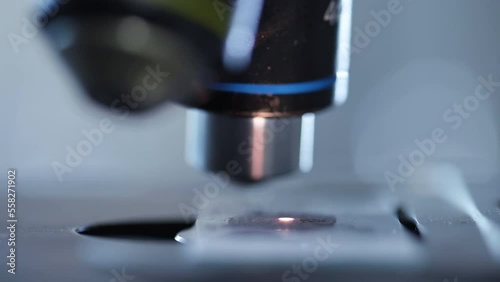 Close up Microscope lens change Magnification of lens for zoom enlarge bacteria or microorganism on slide. Electronic microscope examining a drop of liquid on sample slide by Scientist industrial lab.