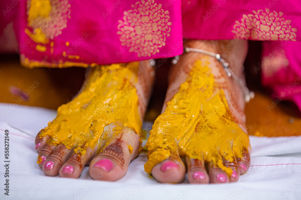 Indian Hindu bride's pre wedding haldi yellow turmeric ceremony fet close up