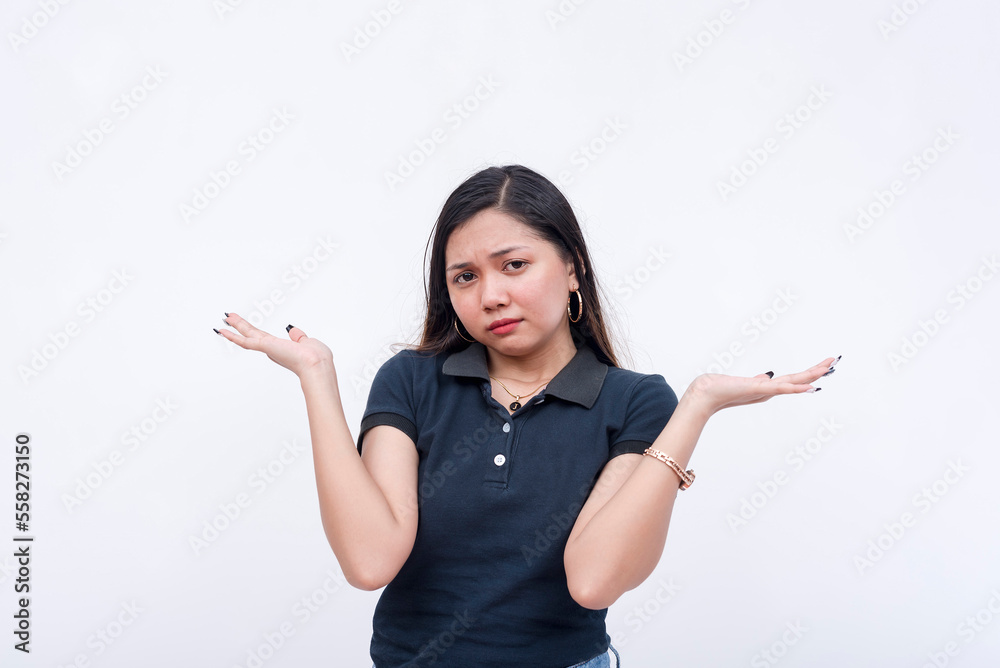 A young annoyed asian woman shrugs, claiming ignorance. Isolated on a white background. A young annoyed asian woman shrugs, claiming ignorance. Isolated on a white background.